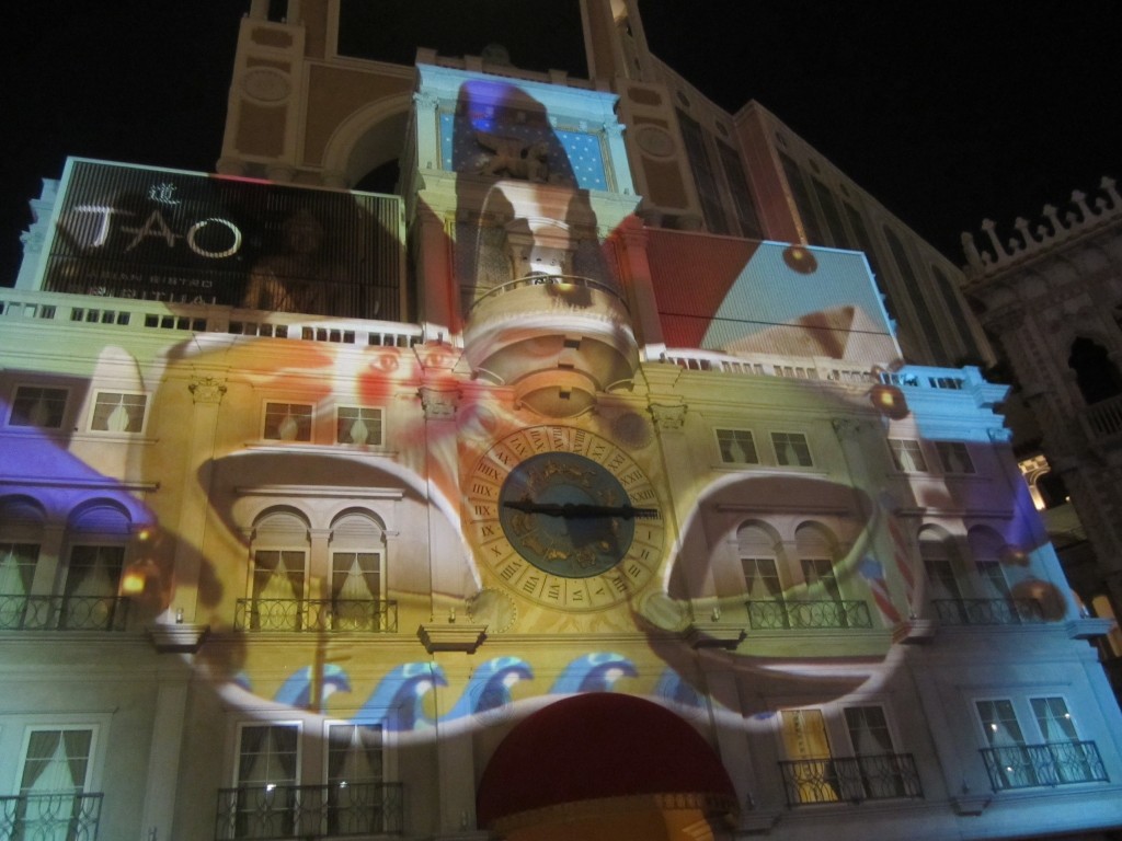A light projection of a Venetian mask on the building