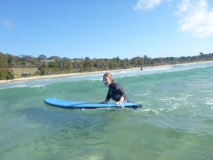 Helen pushes her surfboard through the waves