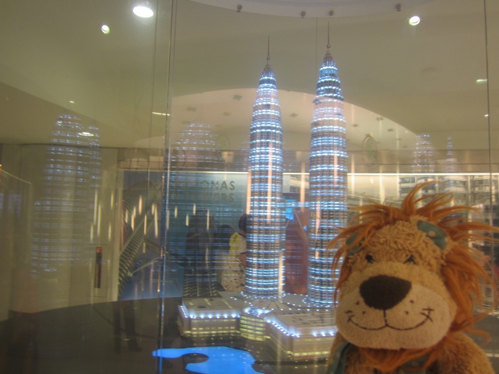Lewis the Lion poses next to a model of the Petronas Towers