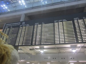 Lewis looks up at the arrivals boards with the Thai script