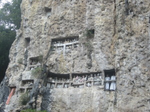 The ancient carved coffins are buried into the rock caves with rows of effigies marking the spot