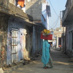 A villager carries a basket on her head